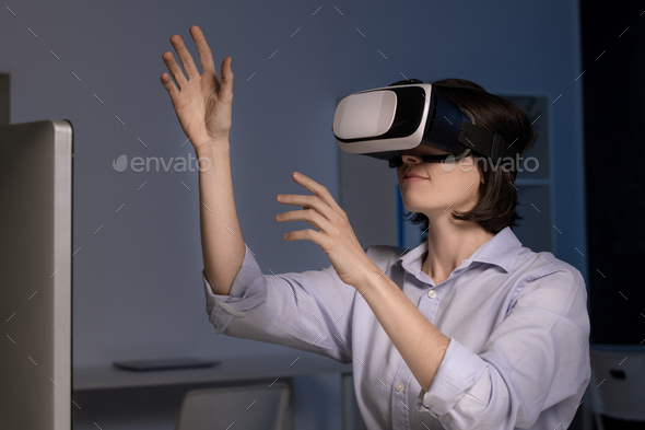 Young female employee with vr headset making virtual presentation