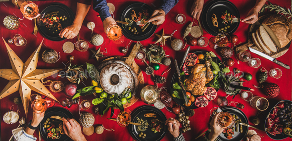 Flat-lay of friends celebrating Christmas over festive table, top Photo by sonyakamoz