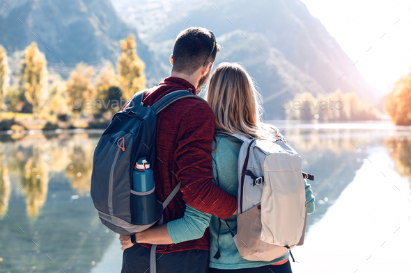 Two travel hikers in love enjoying the nature in front of the lake in mountain. - Stock Photo - Images