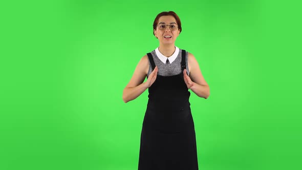 Funny Girl in Round Glasses Is Waving Hand and Showing Gesture Come Here. Green Screen alt