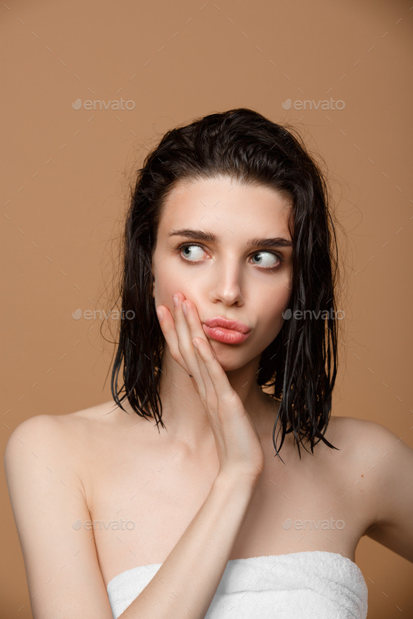 Woman cleaning her face with lotion and cotton pads - Stock Photo - Images