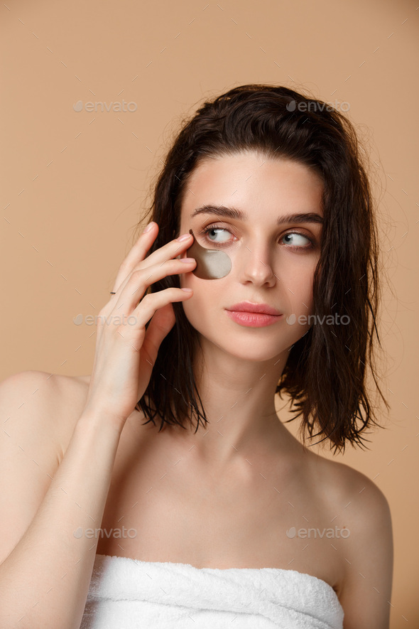 Woman applying under eye moisturising patches - Stock Photo - Images