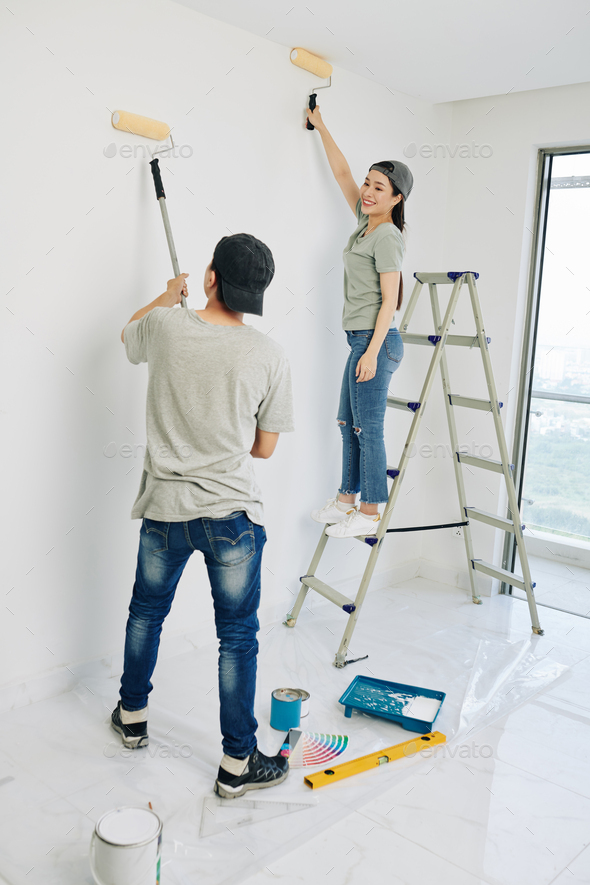 Couple painting room walls
