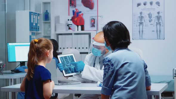 Physician Explaining Xray Using Tablet alt