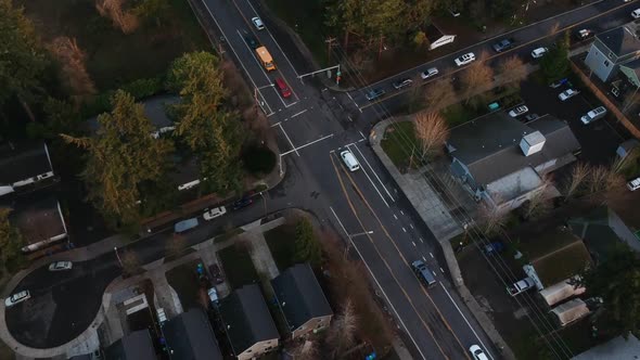 Aerial view of street intersection in city suburb during golden hour at sunset. alt