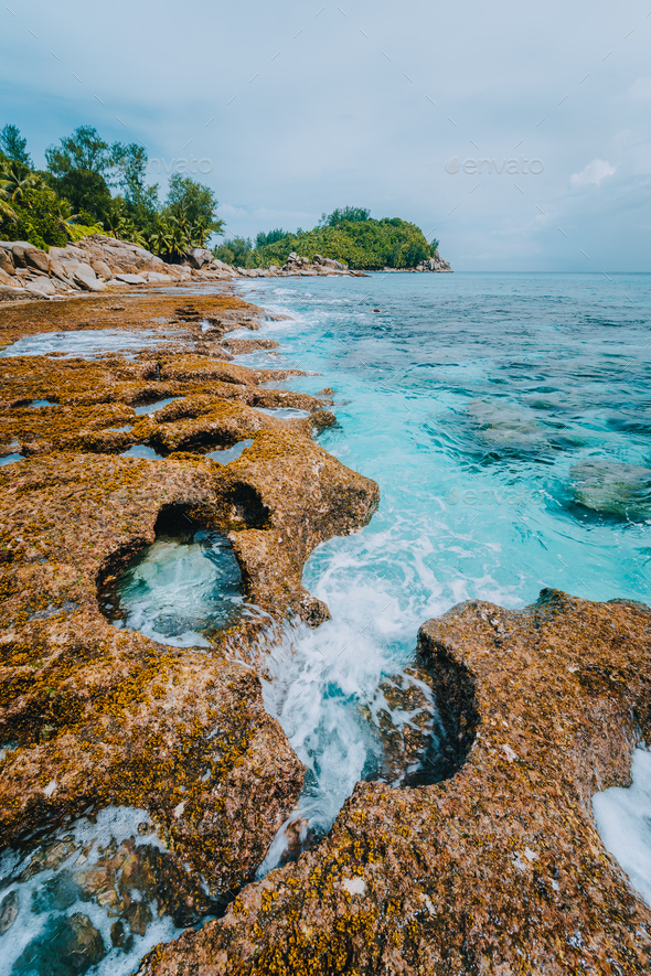 Rugged coastline of paradise beach with granite rocks and blue crystal  clear water on a rough coast