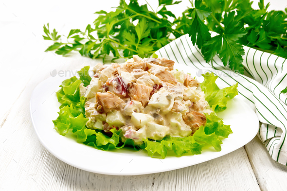 Salad of salmon and cucumber in plate on light board - Stock Photo - Images