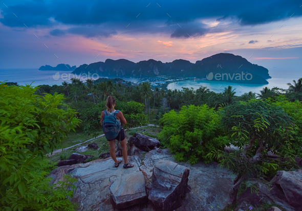 Female Backpacker admires beautiful landscape of the Ko Phi Phi  after sunset, Thailand - Stock Photo - Images