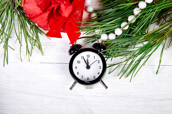 Black Alarm clock and fir tree branch, red christmas decorations - Stock Photo - Images
