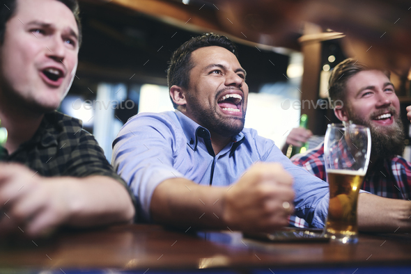 Excited football fans watching american football in the pub Stock Photo ...