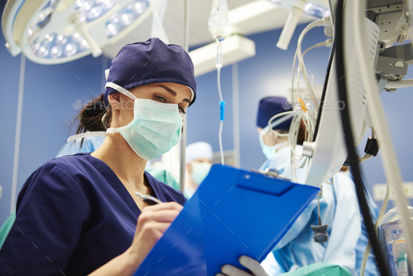 Female nurse examining all the parameters in operating room - Stock Photo - Images