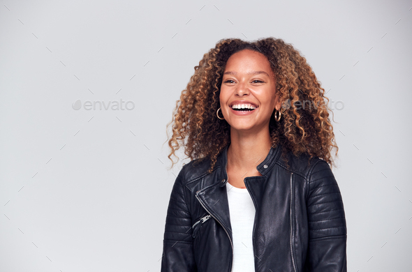 Waist Up Studio Shot Of Happy Young Woman Wearing Leather Jacket Laughing Off Camera