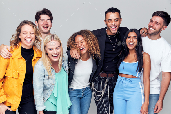 Group Studio Shot Of Young Multi-Cultural Friends Smiling And Laughing At Camera