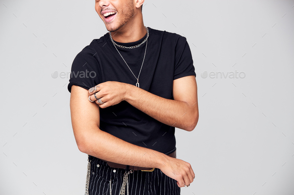 Studio Portrait Of Young Man With Skin Pigmentation Disorder Rolling Up Sleeves Of T Shirt
