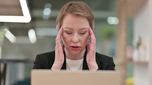 Close Up of Old Businesswoman with Laptop Having Headache  alt