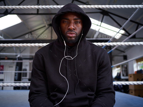 Portrait Of Male Boxer Training In Gym Listening To Music On Headphones In Boxing Ring