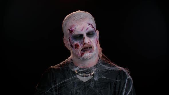 Frightening Man with Halloween Zombie Bloody Wounded Makeup Face Scare Expressions Convulsions alt