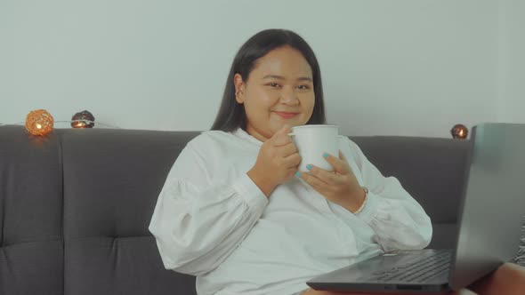 Asian Plus Size Woman Working Online with Laptop at Home Closeup Shot alt
