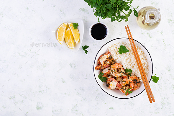 Grilled shrimps and boiled rice. King prawn tails in orange-garlic sauce with parsley. - Stock Photo - Images