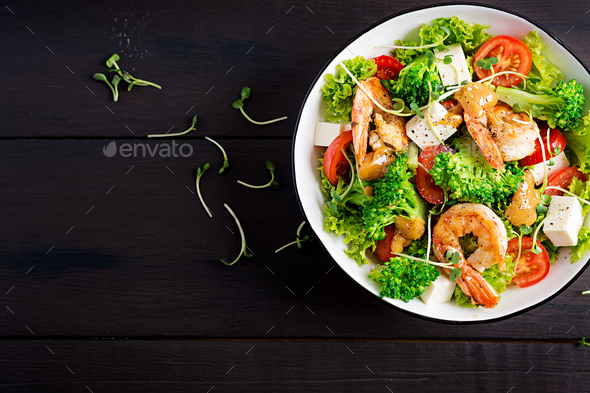 Delicious fresh salad with shrimps / prawns, broccoli, feta cheese, tomatoes, lettuce - Stock Photo - Images