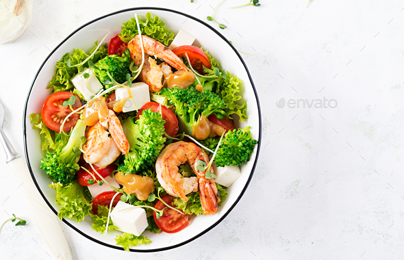 Delicious fresh salad with shrimps / prawns, broccoli, feta cheese, tomatoes, lettuce - Stock Photo - Images