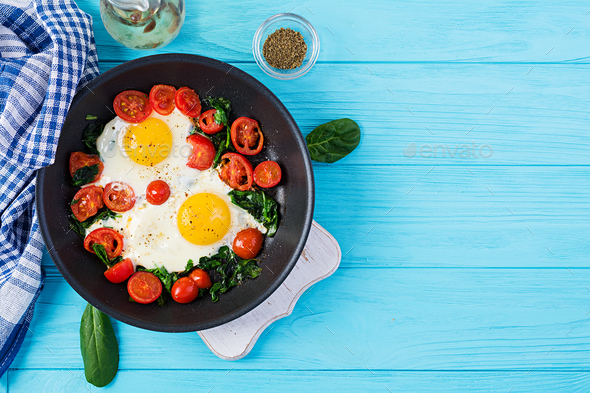 Breakfast. Ketogenic diet food. Fried egg, spinach, and tomatoes. - Stock Photo - Images
