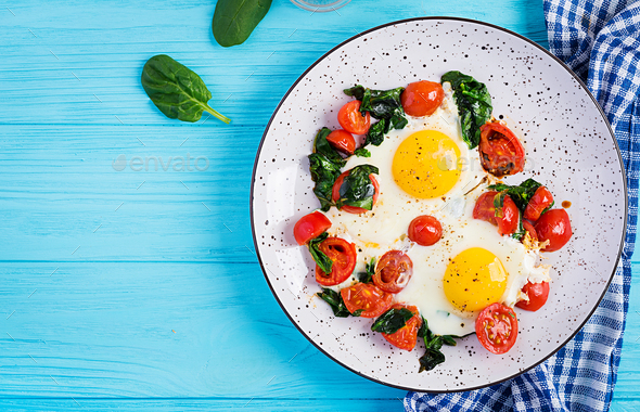 Breakfast. Ketogenic diet food. Fried egg, spinach, and tomatoes. - Stock Photo - Images
