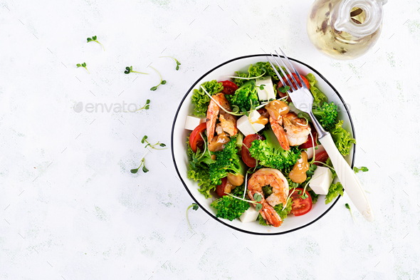 Delicious fresh salad with shrimps / prawns, broccoli, feta cheese, tomatoes, lettuce - Stock Photo - Images