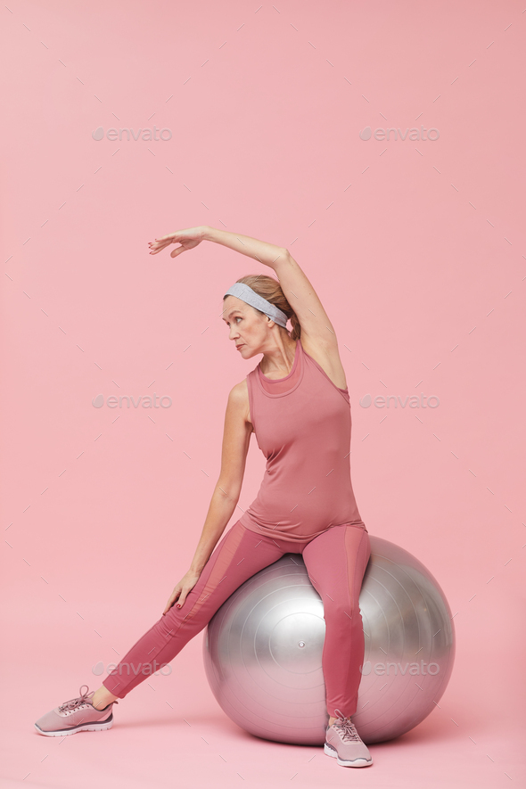 Mature Adult Stretching against Pink - Stock Photo - Images