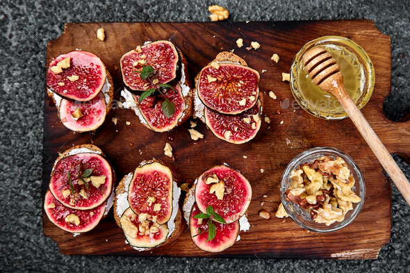 Bruschetta or ctostini with cottage cheese, figs and honey. - Stock Photo - Images