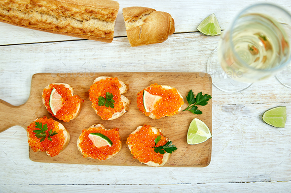 Salmon red caviar in bowl and Sandwiches with on wooden cutting board - Stock Photo - Images