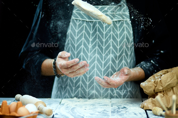 The man, chef cooks throws the dough, flying, freezing in motion. - Stock Photo - Images