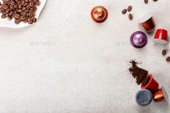 Espresso coffee capsules or pods and coffee beans on grey background
