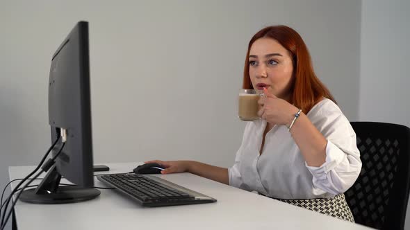 Woman Drinking Coffee While Working on Computer in Office 4K alt