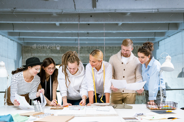 Group of young creative designers discussing stuff for new fashion collection - Stock Photo - Images