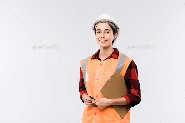 Successful young female engineer in protective helmet and orange jacket - Stock Photo - Images