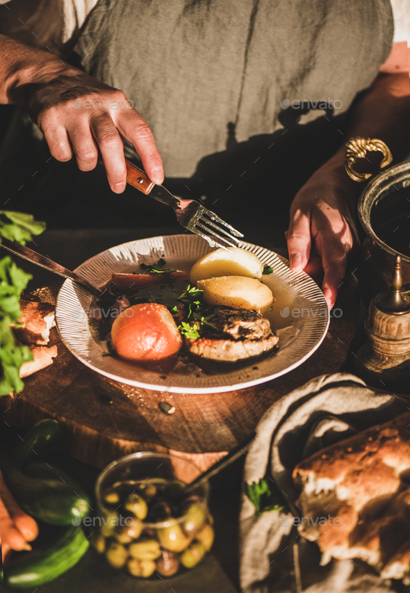 Woman eating Turkish meat soup Haslama with vegetables with fork - Stock Photo - Images
