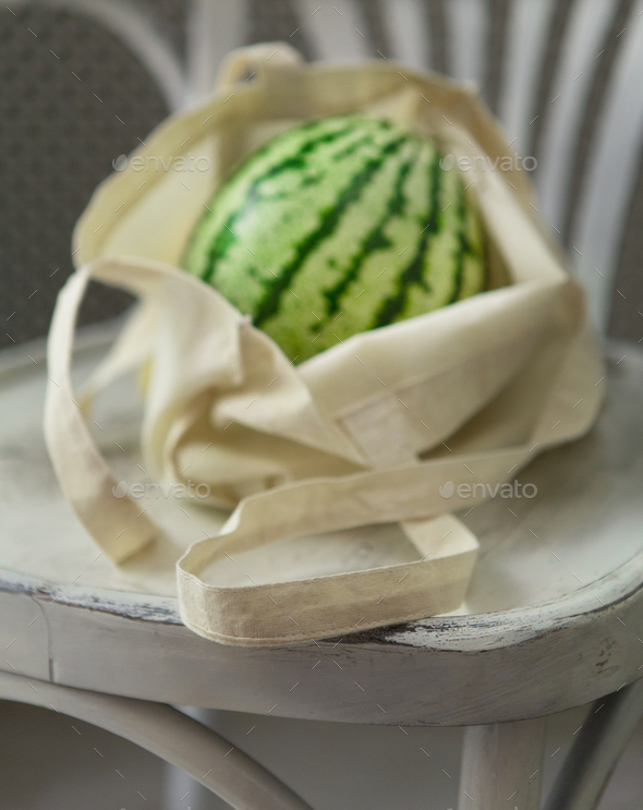 Organic big watermelon in zero waste shopping bag on chair