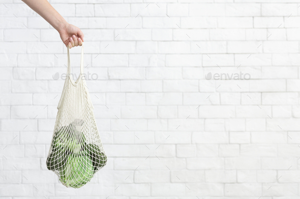 Eco and fresh green vegetables collecting inside mesh shopping bag - Stock Photo - Images