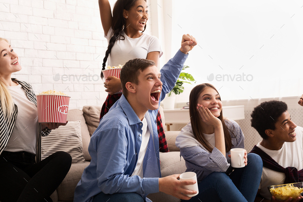 Friends Cheering While Watching Football On Tv Stock Photo