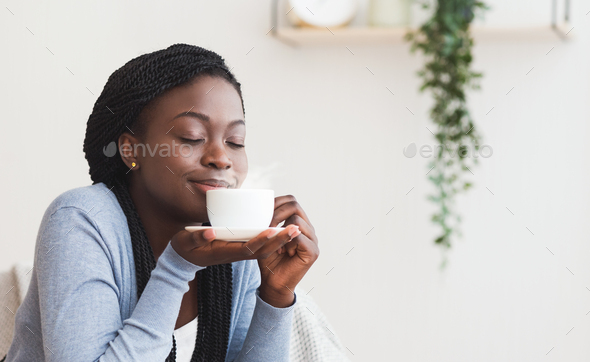 Close-up of a woman holding a cup of black coffee