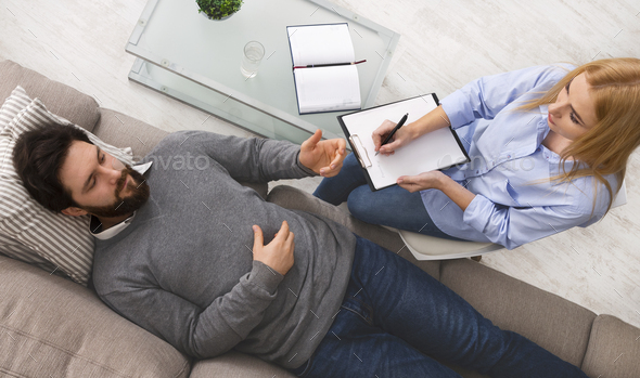 Depressed man discussing his inner fears with psychologist - Stock Photo - Images