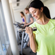 Happy fit woman exercising in a gym to stay healthy Stock Photo by
