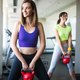 Happy fit woman exercising in a gym to stay healthy Stock Photo by
