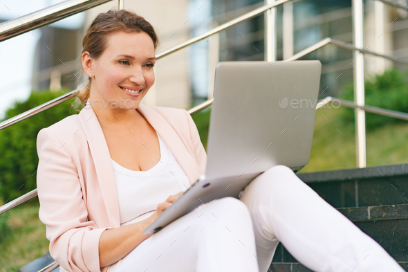 Businesswoman is working on a computer on the street. - Stock Photo - Images