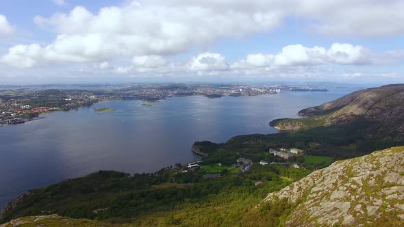 The woman is hiking on the top of a mountain in Norway, aerial view alt