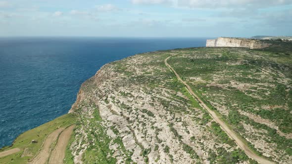 AERIAL: Rocky Hills near Ta Cenc Cliffs and Blue Mediterranean Sea