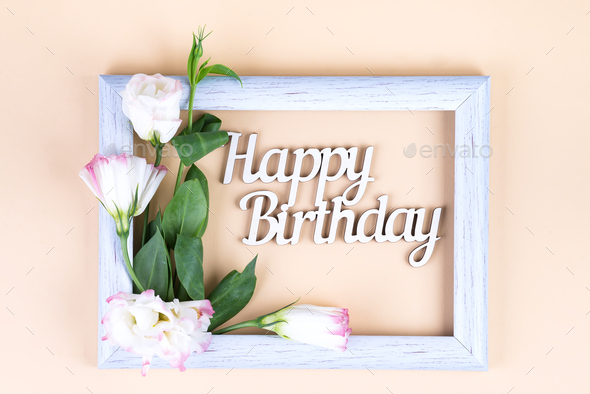 Empty white frame and flowers eustoma on beige paper background with copy space. Birthday concept - Stock Photo - Images
