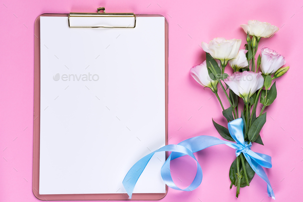 Minimal composition with a Eustoma flowers in an envelope with clipboard on a pink background, top - Stock Photo - Images