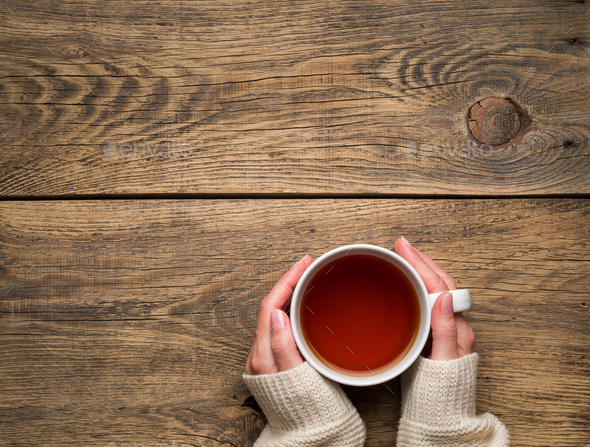 Female hands holding a mug of hot black tea. Cold winter - Stock Photo - Images